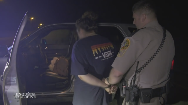 تمهيداً لإعتقالها ، هُنا شّرطي المُرور يقوم بوضع الأصفاد لسائقة مركبة ضُبطت بحيازة و تدخين مخدّر المارجوانا داخل السيارة :